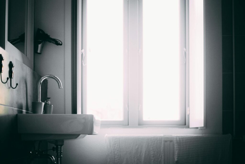 Bright minimalist bathroom featuring a sleek sink and natural light source.