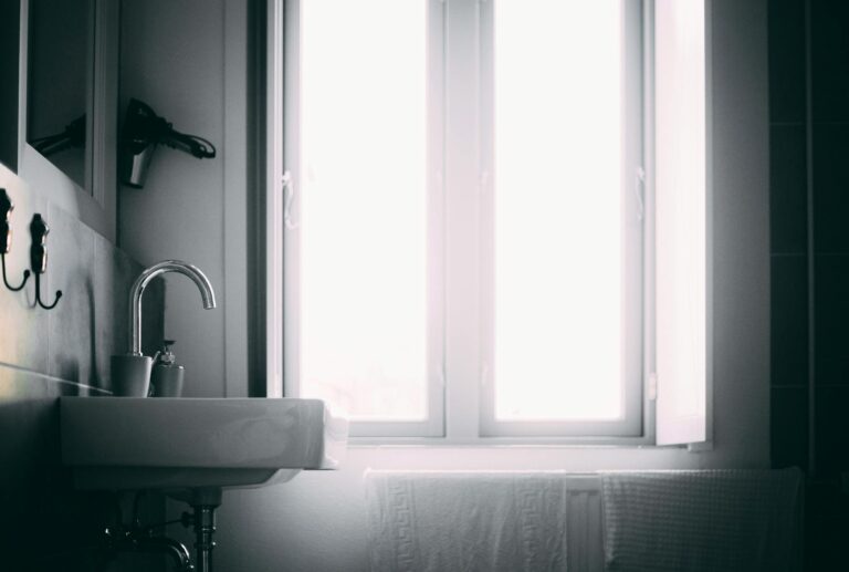 Bright minimalist bathroom featuring a sleek sink and natural light source.